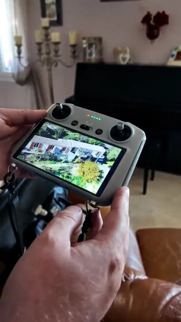 Image d'une commande de drone en train de filmer une maison