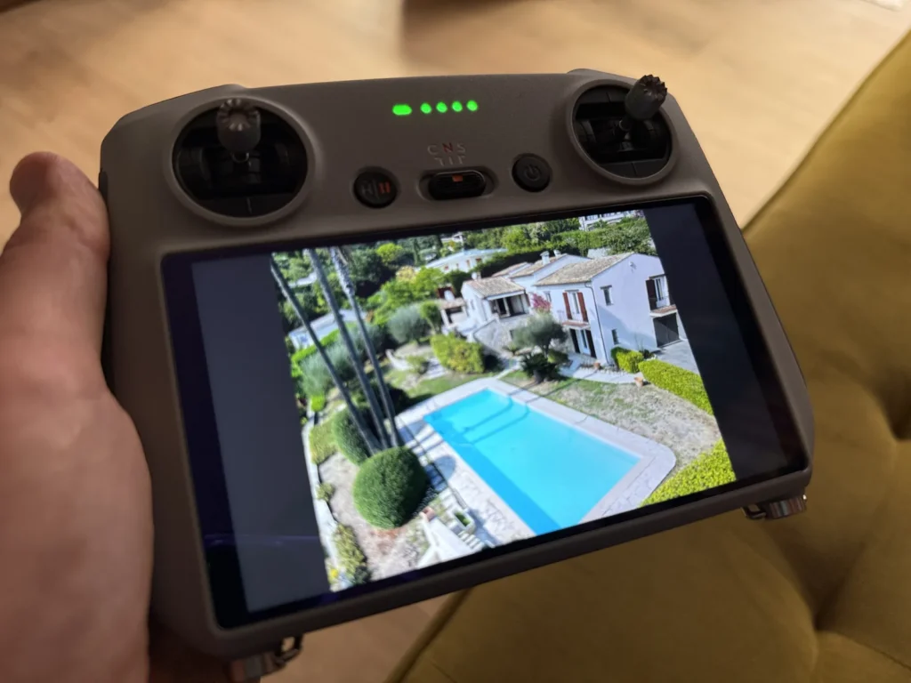 Télécommande de drone montrant une propriété lors de la visite d’estimation